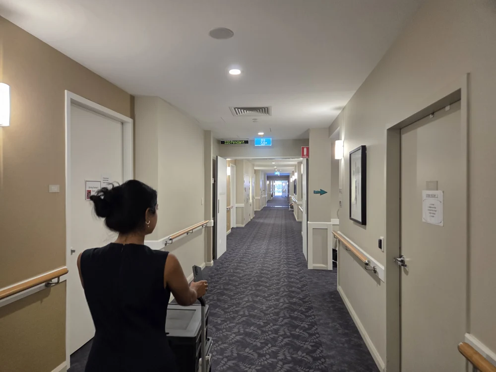 Usmi bringing portable ultrasound equipment through an aged-care facility
