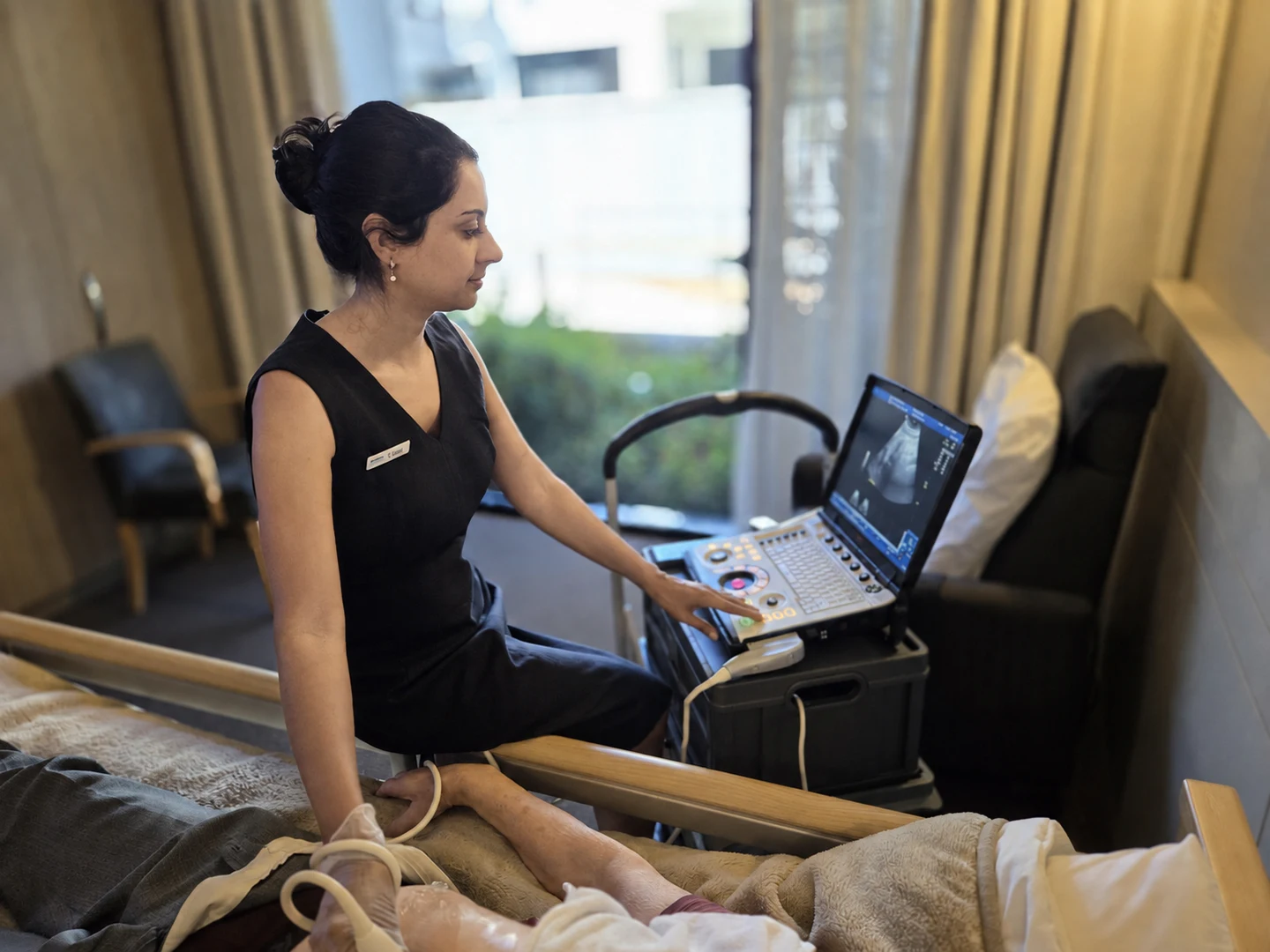 Usmi performing a bedside ultrasound with portable imaging equipment