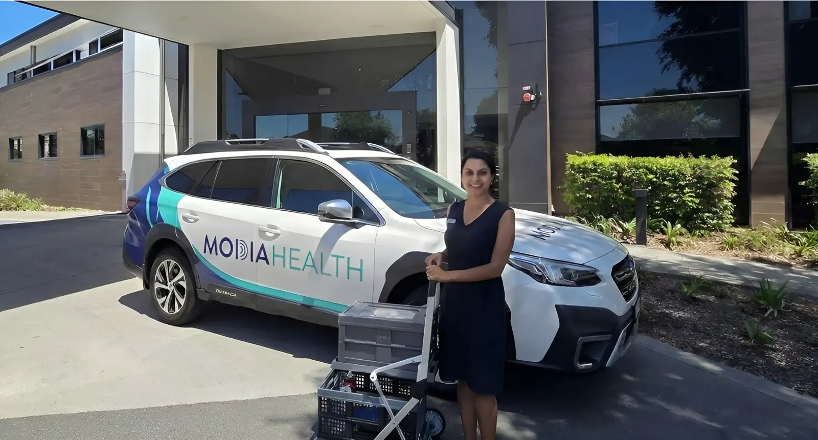 Usmi beside a Modia Health vehicle with mobile imaging equipment